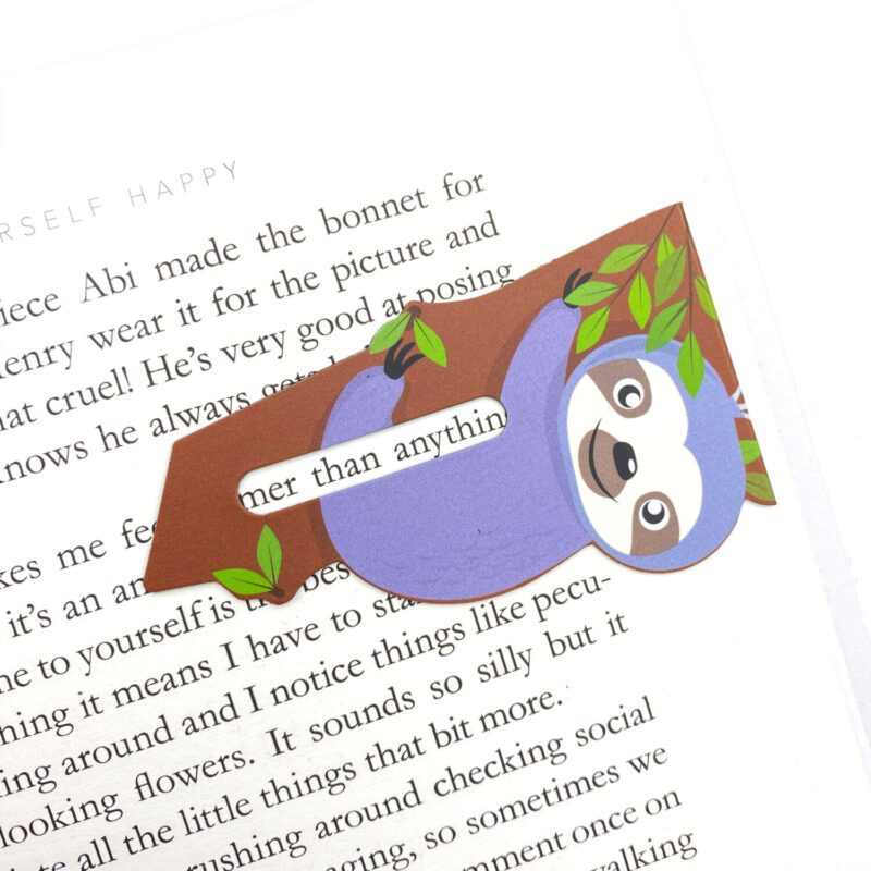 Line marker book mark that you can put over the last line you read to keep a record of where you're up to. Showing the line marker in a book. Sloth design.