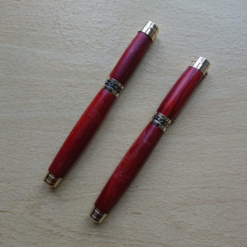 Two pen set made from walnut with broader, wider bodies, though standard width, but shaped grip area. The pens are handmade. One is a fountain pen and one is a retractable tip pen