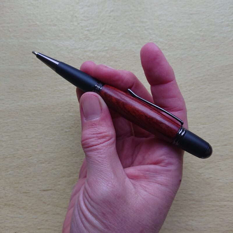 Mahogany handmade wooden pen with wider, broader body and black styling. Retractable tip.