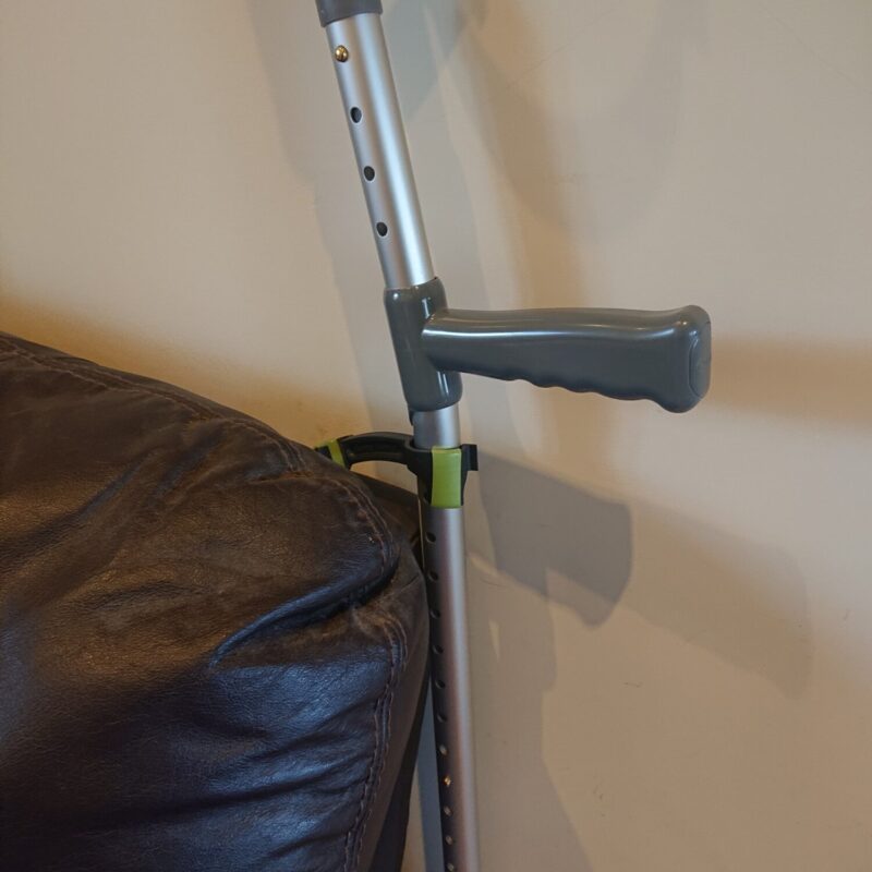 bridgit stick and crutch clip supporting a crutch against the back of a settee to stop it falling down